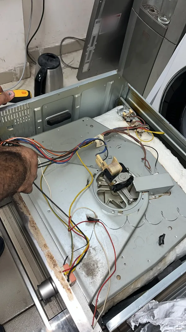 Ankastre fırının arka panelinde fan motoru ve kablo bağlantıları kontrol ediliyor